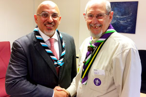 Nadhim Zahawi shaking hands with Tony Guy wearing a Stratford District necker